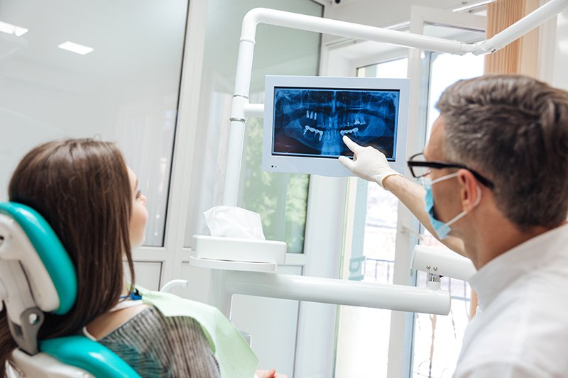 dentist pointing out signs of a cavity on dental x-ray