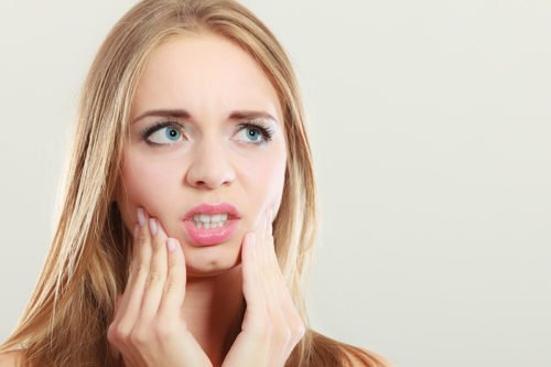 Young woman suffering from dental pain