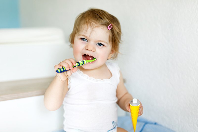 Little Baby Girl Holding Toothbrush