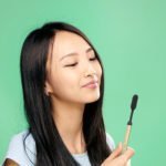 Woman with gold toothbrush